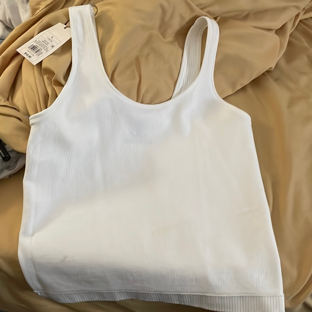 White tank top NWT surprise logo. (Sample)